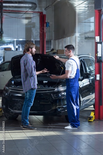 Customer talking with automobile mechanic
