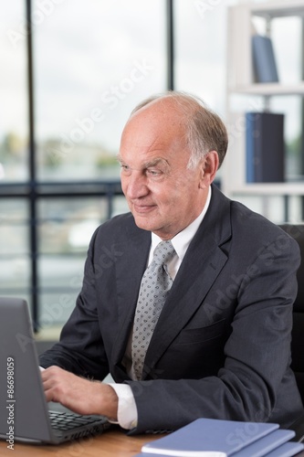 Elderly man working on laptop