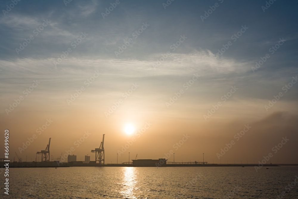 Sea port with crane and sunrise or sunset
