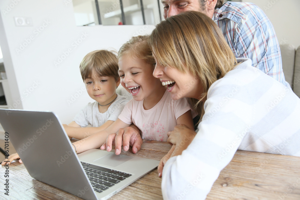 Parents with kids at home using laptop computer Parents with kids at home using laptop computer