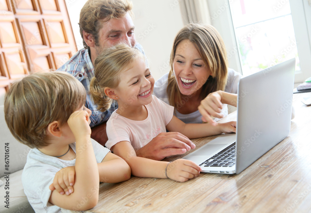 Parents with kids at home using laptop computer Parents with kids at home using laptop computer