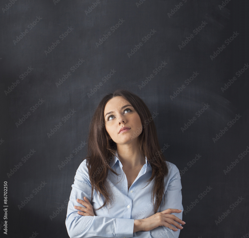 Businesswoman looking up with empty blackboard Businesswoman looking up with empty blackboard