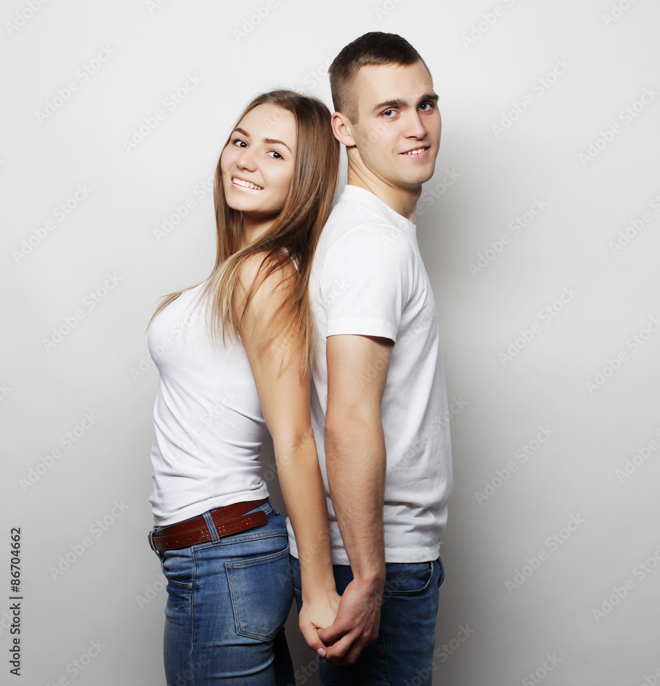 lovely happy couple hugging over grey background. lovely happy couple hugging over grey background.