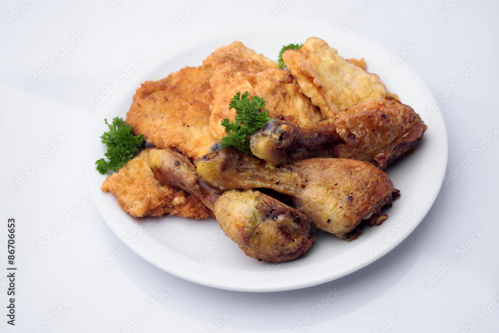 Chicken drumsticks and pork chops on plate Chicken drumsticks and pork chops on plate