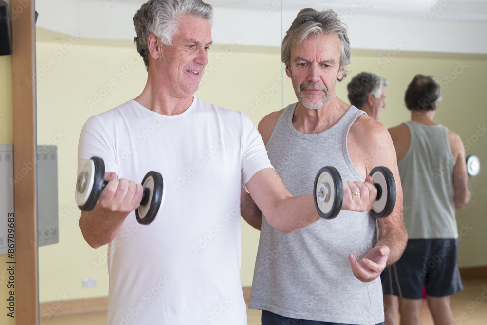 Men using weights together Men using weights together