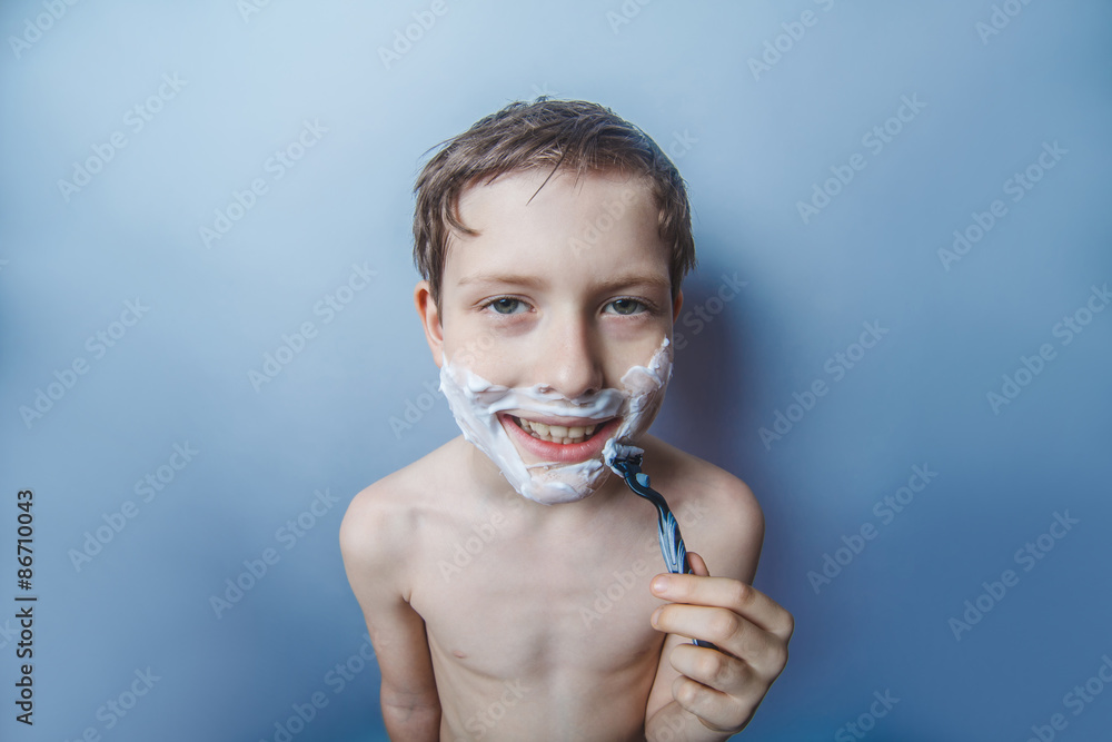 Fototapeta premium Boy teenager European appearance decade shaves face on a gr