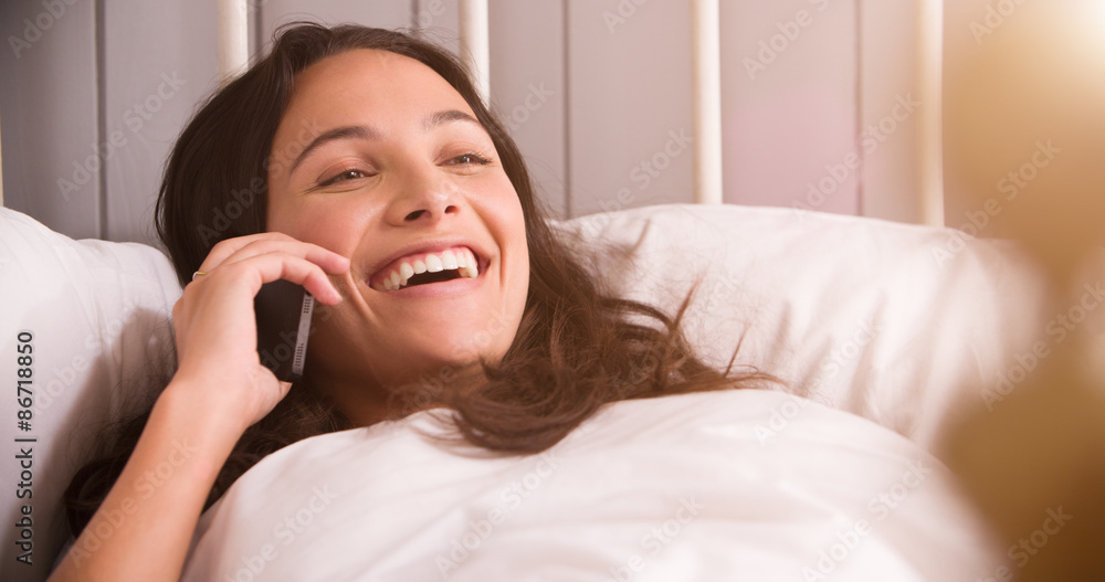 Woman Lying In Bed Having Conversation On Mobile Phone Woman Lying In Bed Having Conversation On Mobile Phone