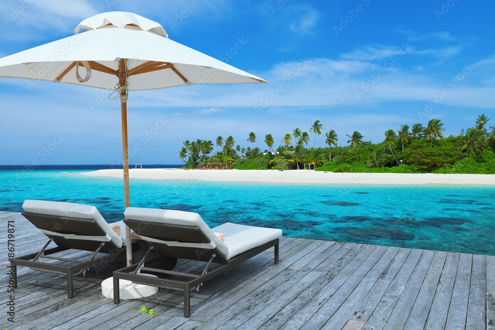 Two empty sunbed on the water villa, beautiful seascape, relaxation on Maldives island