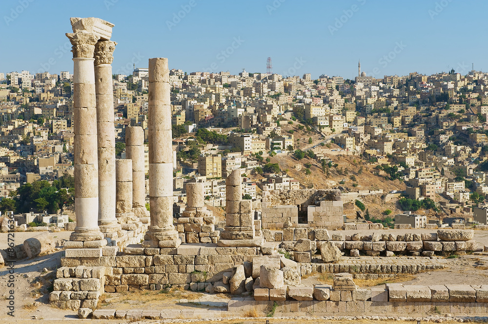 View to the ancient stone columns at the Citadel of Amman with the Amman city at the background in Amman, Jordan.