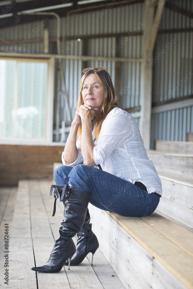 Thoughtful mature woman in jeans and high heels Stock-Foto | Adobe Stock