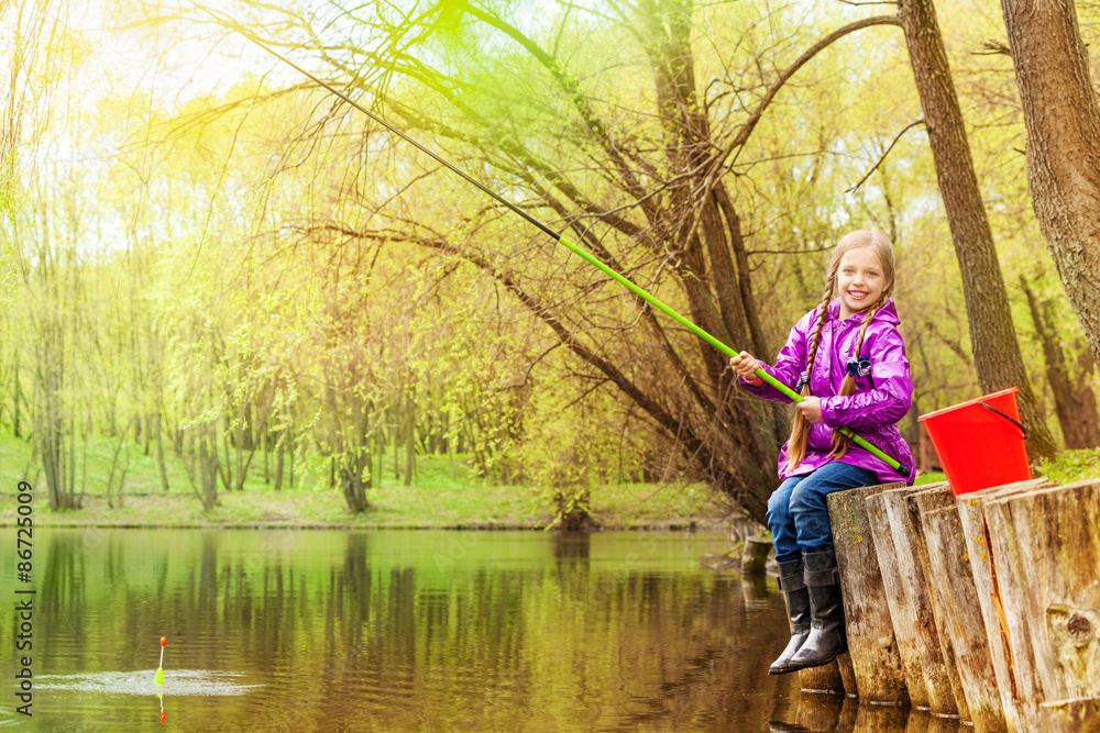 Smiling small girl fishing near beautiful pond Smiling small girl fishing near beautiful pond