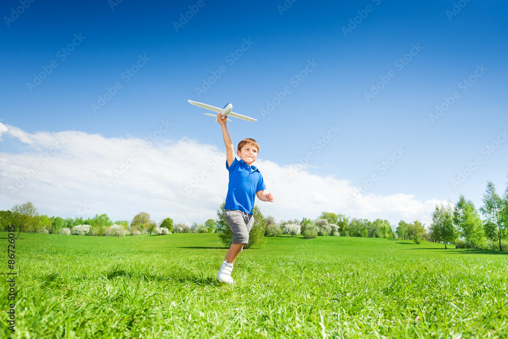 Happy boy holding airplane toy during running Happy boy holding airplane toy during running