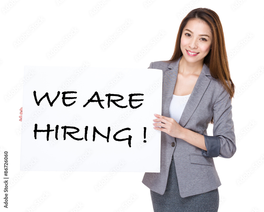 Businesswoman present on white board with phrase of we are hirin Businesswoman present on white board with phrase of we are hirin