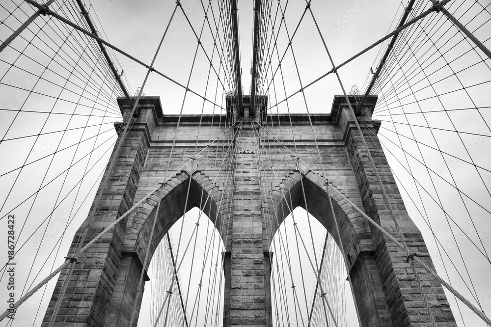 Fototapeta premium Brooklyn Bridge w Nowym Jorku zamyka detal architektoniczny w ponadczasowej czerni i bieli