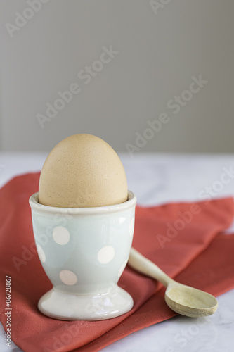 egg in egg cup with napkin on marble table