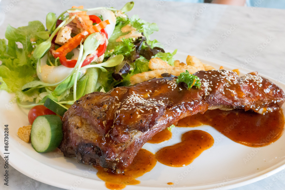 rib steak in white plate with salad