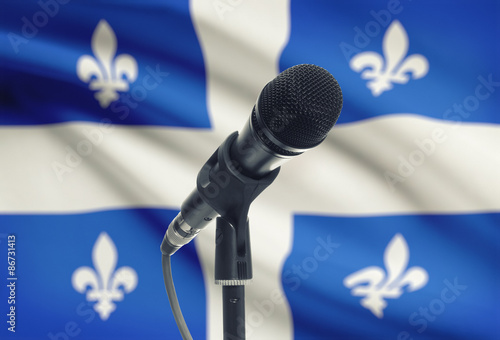 Slika na platnu Microphone on stand with Canadian province flag on background - Quebec