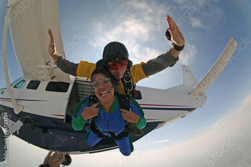 Skydive tandem exit from the plane Beautiful smile girl