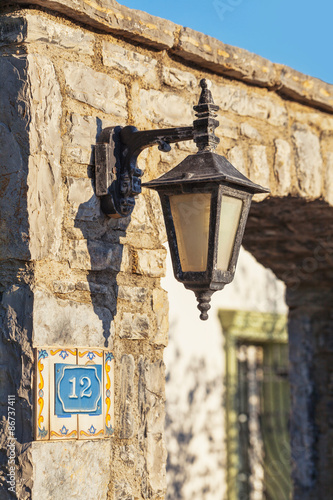 Lantern vintage on the wall of an old stone seafront 