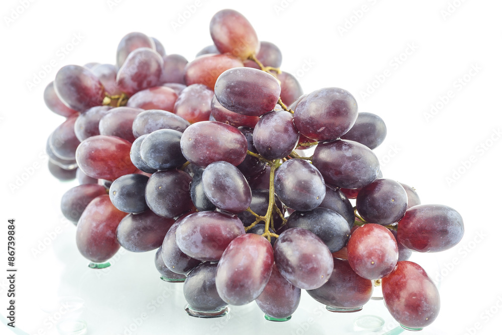 Fototapeta premium Wet cluster of grapes on a glass table