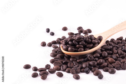 Spread coffee seeds on wooden spoon isolated on white background
