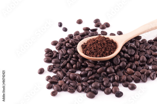 Coffee beans and ground coffee on wooden spoon isolated on white