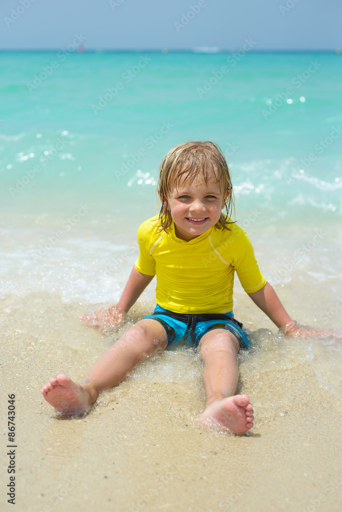 Smiling little boy plays at a tropical beach Smiling little boy plays at a tropical beach