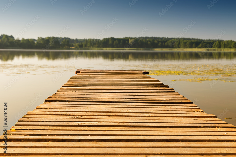 Obraz premium Empty footbridge on a lake. Summer background.