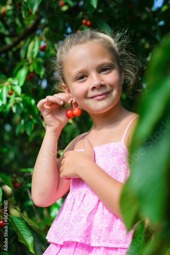 Portrait of pretty girl with earrings of cherrys in cherry garden