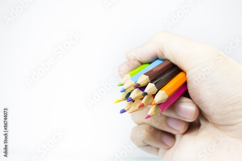 color pencils in hand on isolated background