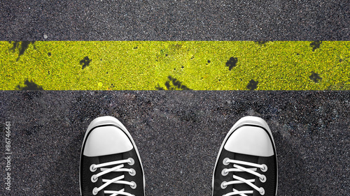 Photography Cross the yellow line ? Concept illustration showing shoes in front of a yellow line