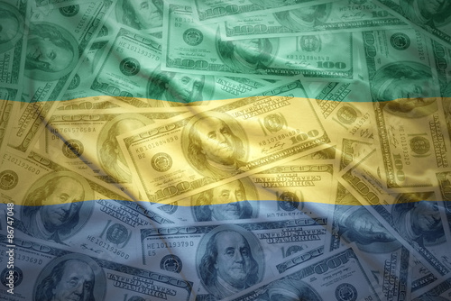 colorful waving gabonese flag on a american dollar money background