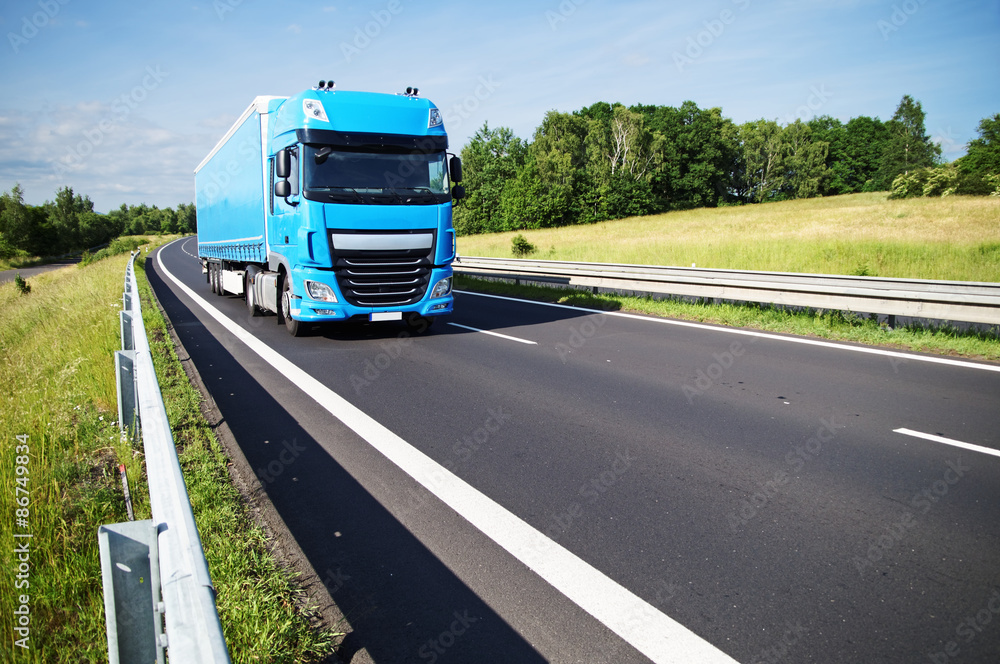 Blue truck on asphalt expressway in the countryside Blue truck on asphalt expressway in the countryside