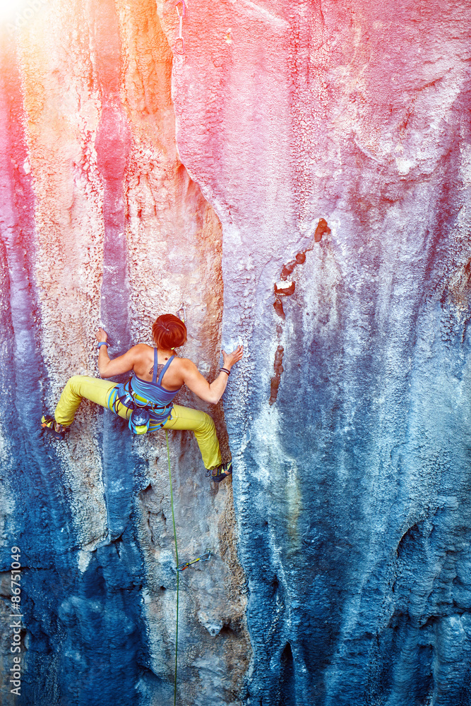 Obraz premium Rock climber climbing up a cliff