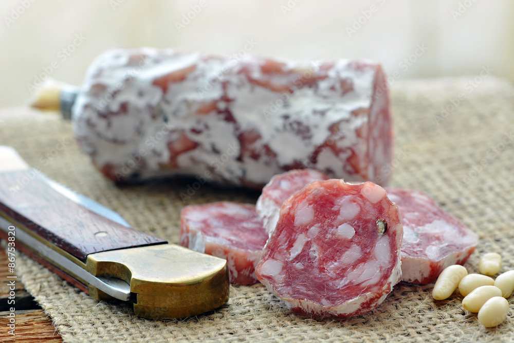 Salami / Rohwurst - Auf Jute mit Messer und Pinienkernen / Makro Salami / Rohwurst - Auf Jute mit Messer und Pinienkernen / Makro