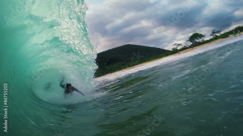 Surfer on Blue Ocean Wave Getting Barreled and Wiping Out. Shorebreak.