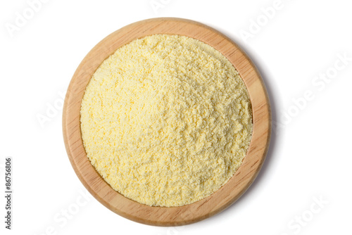 uncooked yellow corn flour in the wooden plate, tilt shift lens