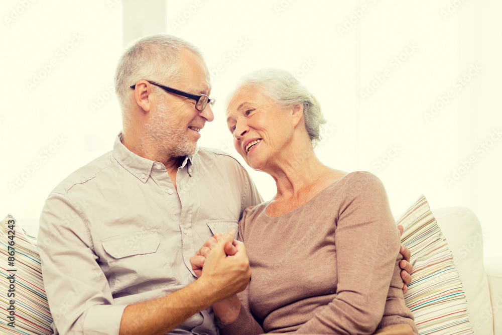 happy senior couple hugging on sofa at home happy senior couple hugging on sofa at home