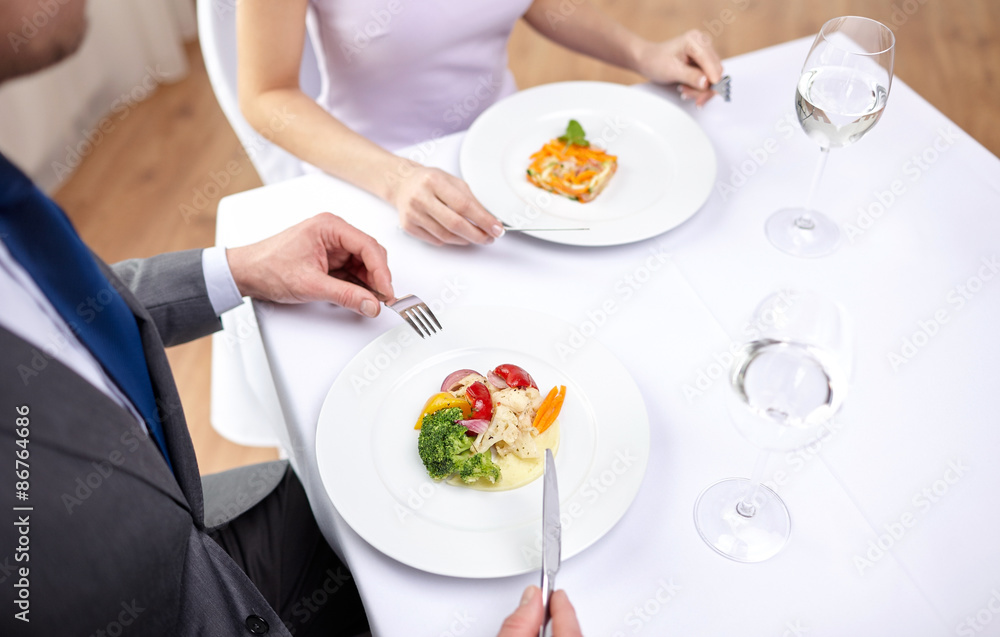 close up of couple eating appetizers at restaurant close up of couple eating appetizers at restaurant