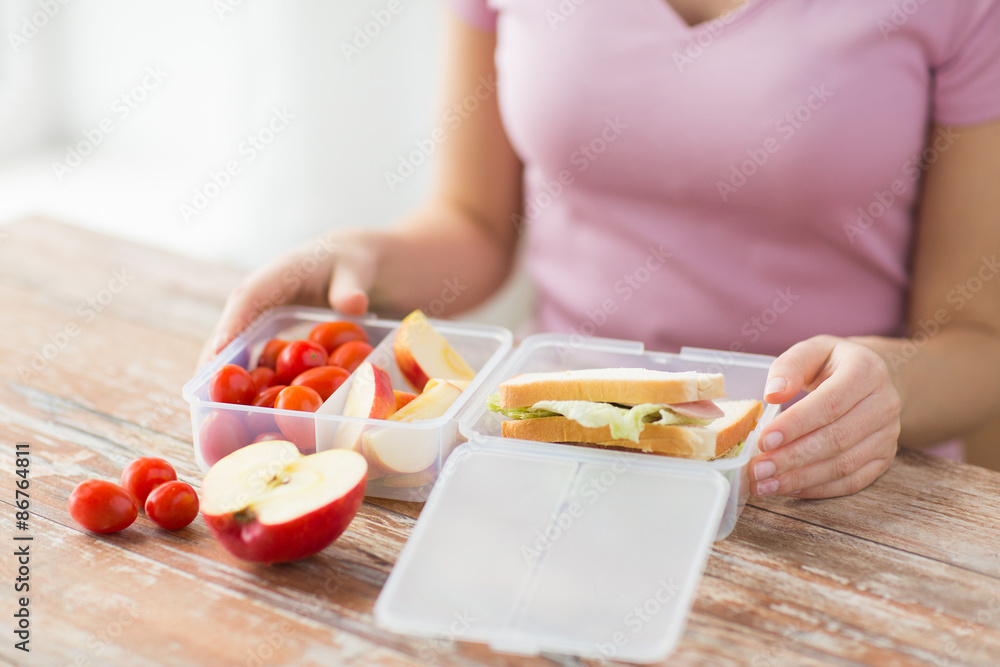 close up of woman with food in plastic container close up of woman with food in plastic container