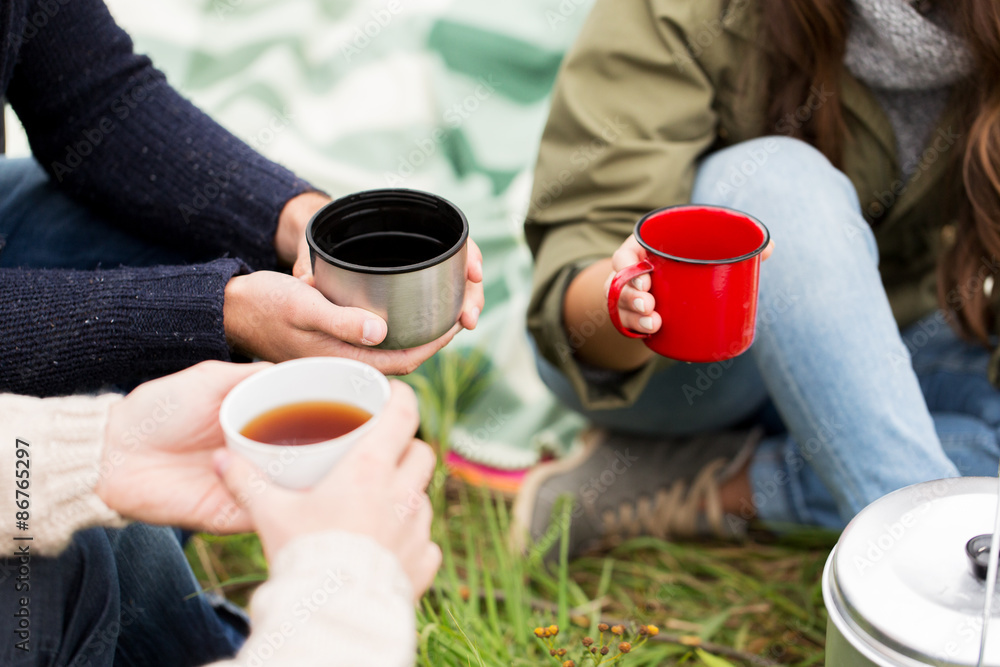 close up of hikers drinking tea from cups at camp close up of hikers drinking tea from cups at camp