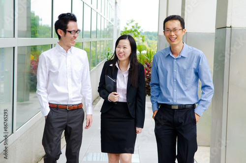 Asian business people having conversation while walking