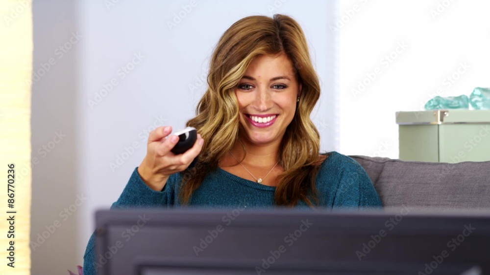 Young woman watching TV on couch Young woman watching TV on couch