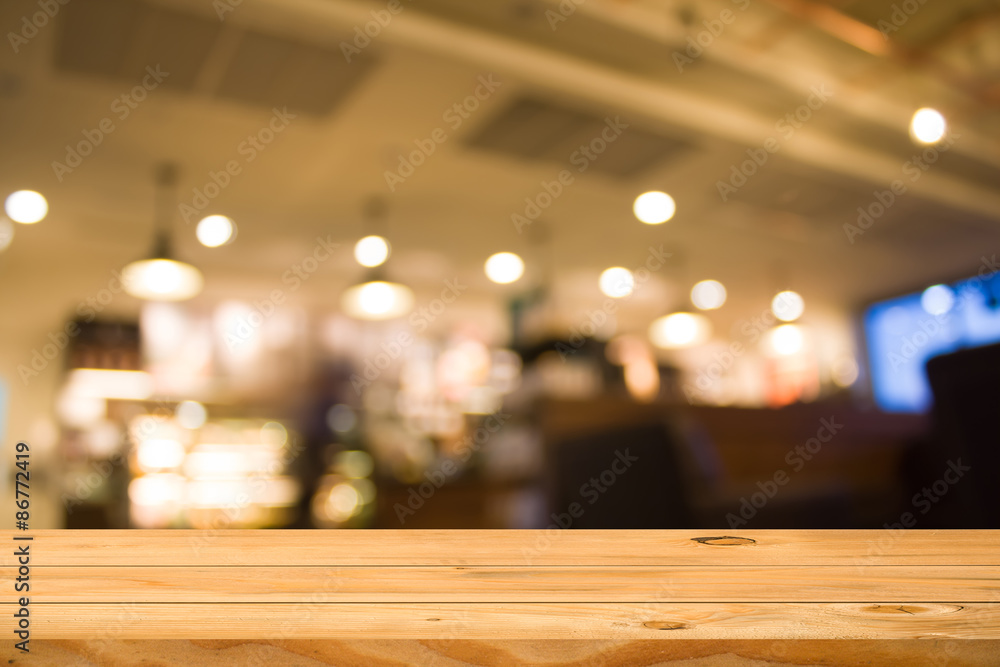 Empty wooden table over blur coffee shop background. Ready for product display montage.