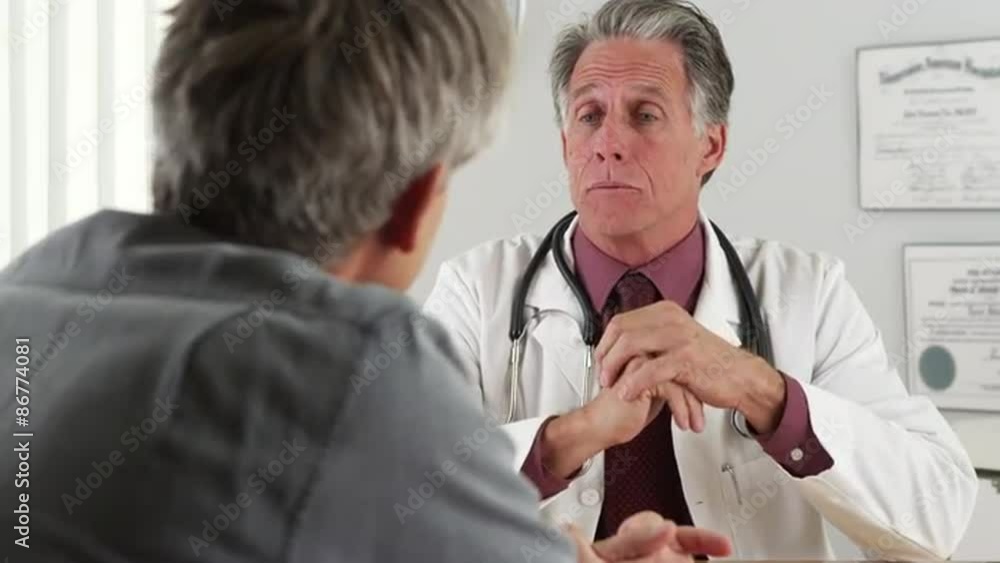 Doctor talking with elderly patient in his office Doctor talking with elderly patient in his office