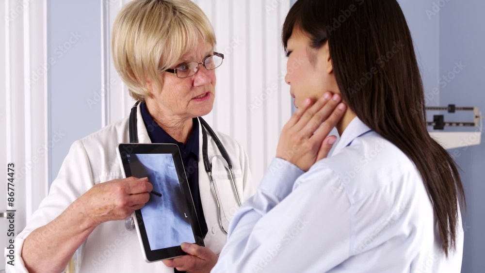 Senior doctor explaining neck x-ray to patient Senior doctor explaining neck x-ray to patient