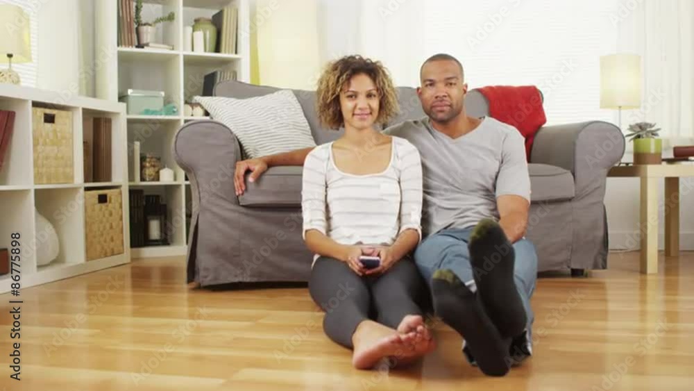 Cute black couple sitting on floor in living room Cute black couple sitting on floor in living room
