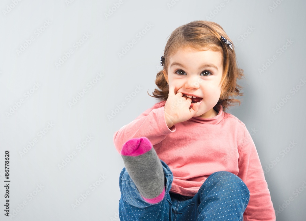 Cute girl sitting and laughing over white background Cute girl sitting and laughing over white background