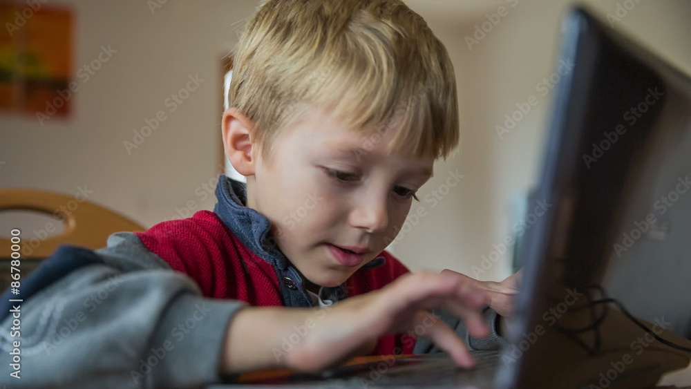 Child typing on keyboard of laptop computer Child typing on keyboard of laptop computer