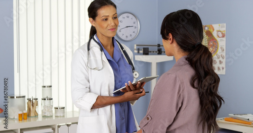 African American gynecologist talking to patient with tablet photo